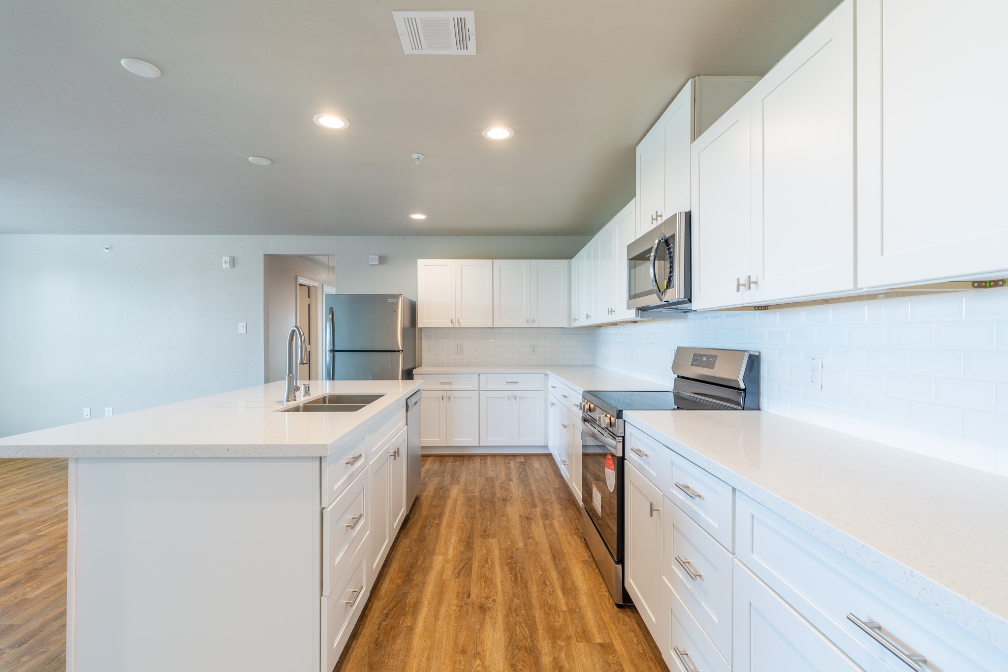 203 Park Place Circle, Unit D Waller, TX 77484 - Photo 10 of 29 a large kitchen with stainless steel appliances a sink a stove and a refrigerator