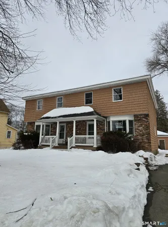 a front view of a house with a yard covered in snow