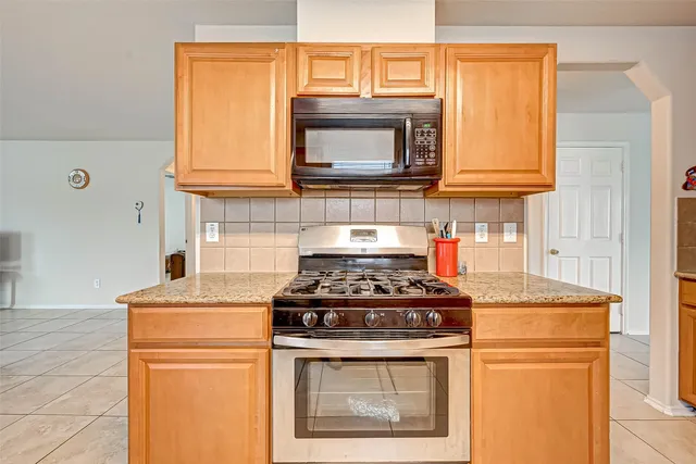 a kitchen with stainless steel appliances granite countertop a stove and a microwave