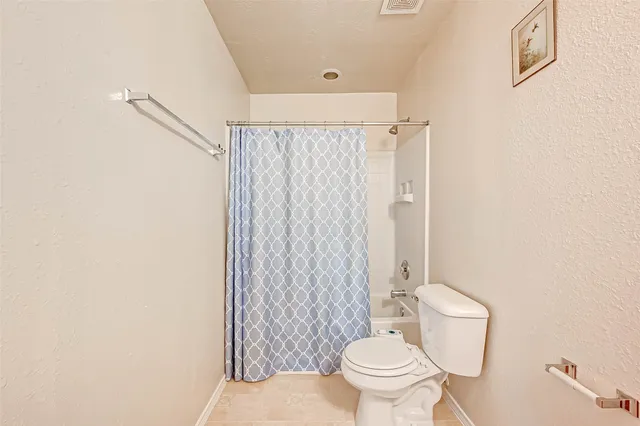 a white toilet sitting next to a shower curtain