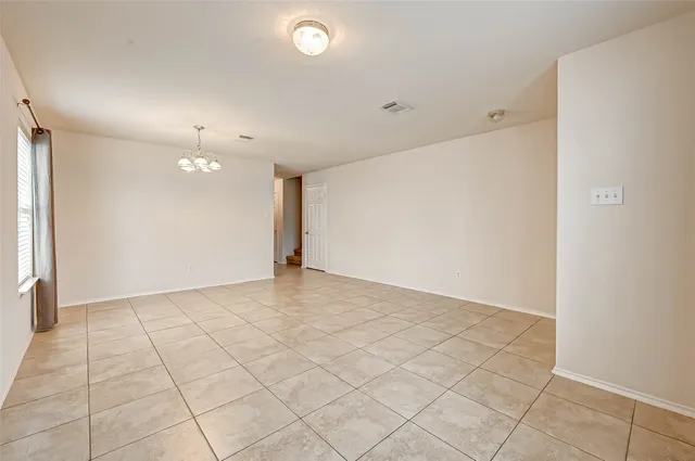 an empty room with kitchen view