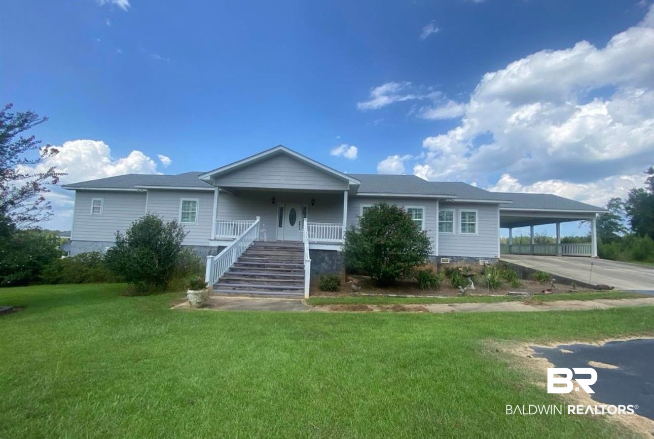 441 Ramah Road Evergreen, AL 36401 - Photo 1 of 1 Ranch-style house featuring a carport, a porch, and a front lawn