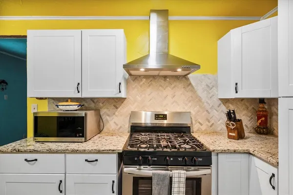 a kitchen with a stove and a white cabinets