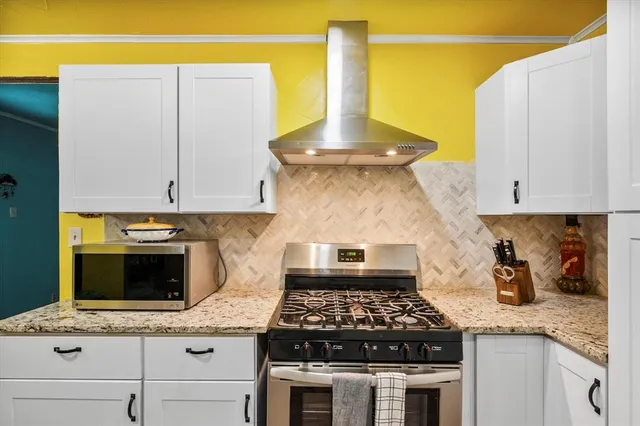 a kitchen with a stove and a white cabinets