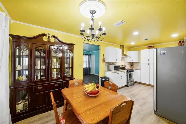 a view of a dining room with furniture a chandelier and wooden floor