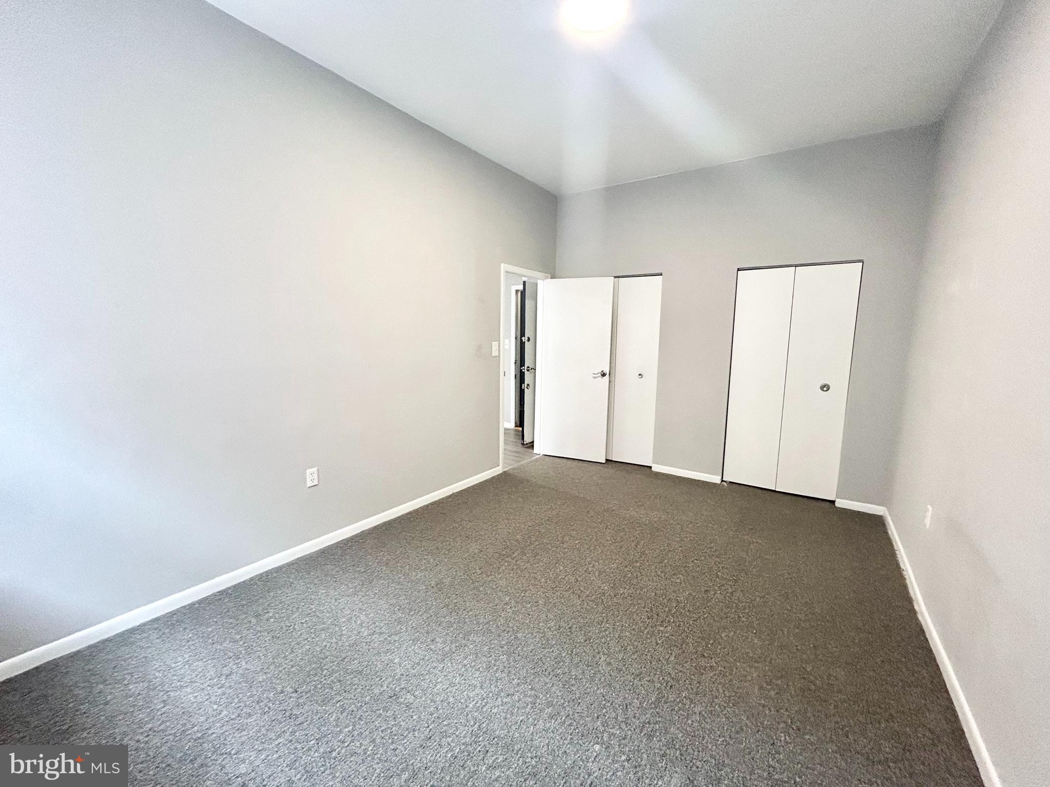an empty room with windows and closet