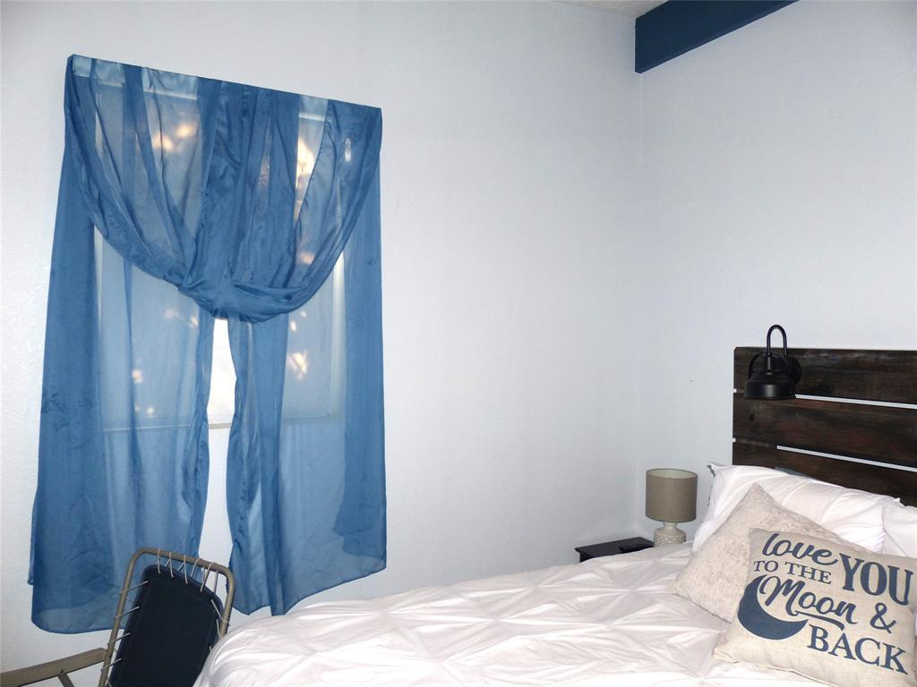 101 South Loop Drive Brady, TX 76825 - Photo 21 of 34 a bedroom with a bed and wooden floor