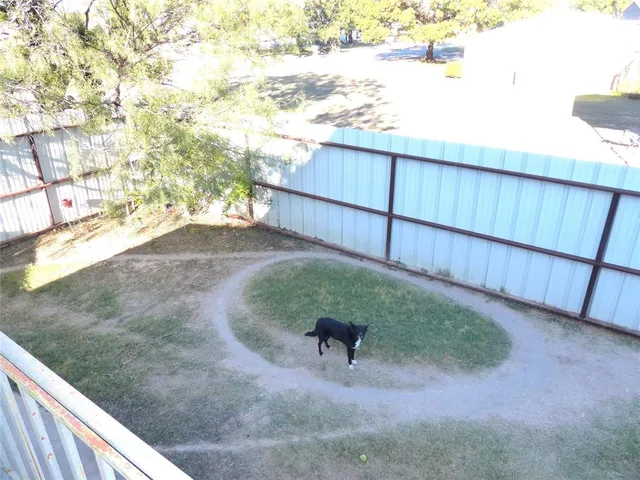 a view of backyard and wooden fence