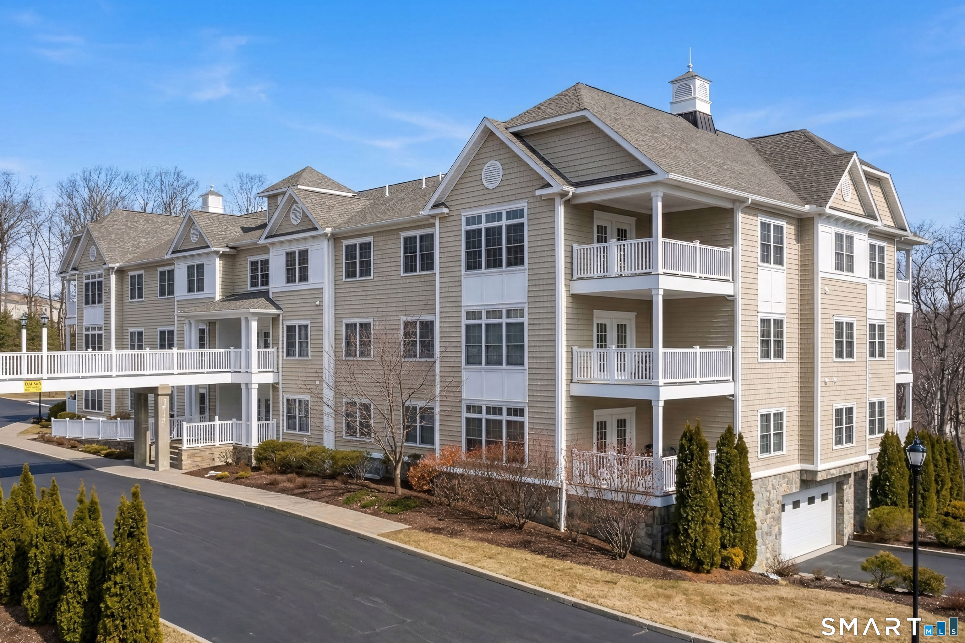 77 Sunset Lane, Unit 335 Ridgefield, CT 06877 - Photo 1 of 25 a front view of a residential apartment building with a yard