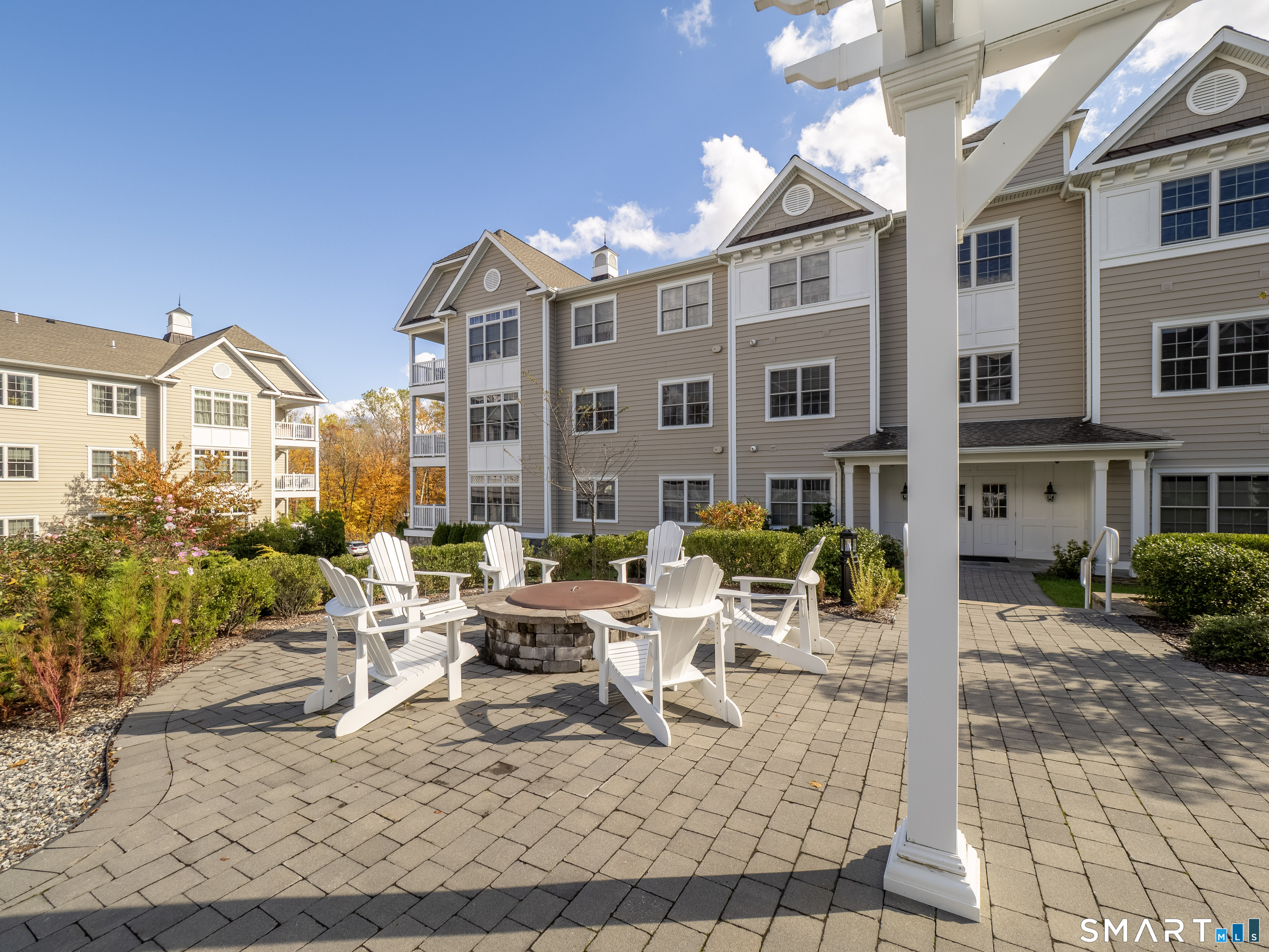 77 Sunset Lane, Unit 335 Ridgefield, CT 06877 - Photo 17 of 25 a view of a patio with couches table and chairs and potted plants