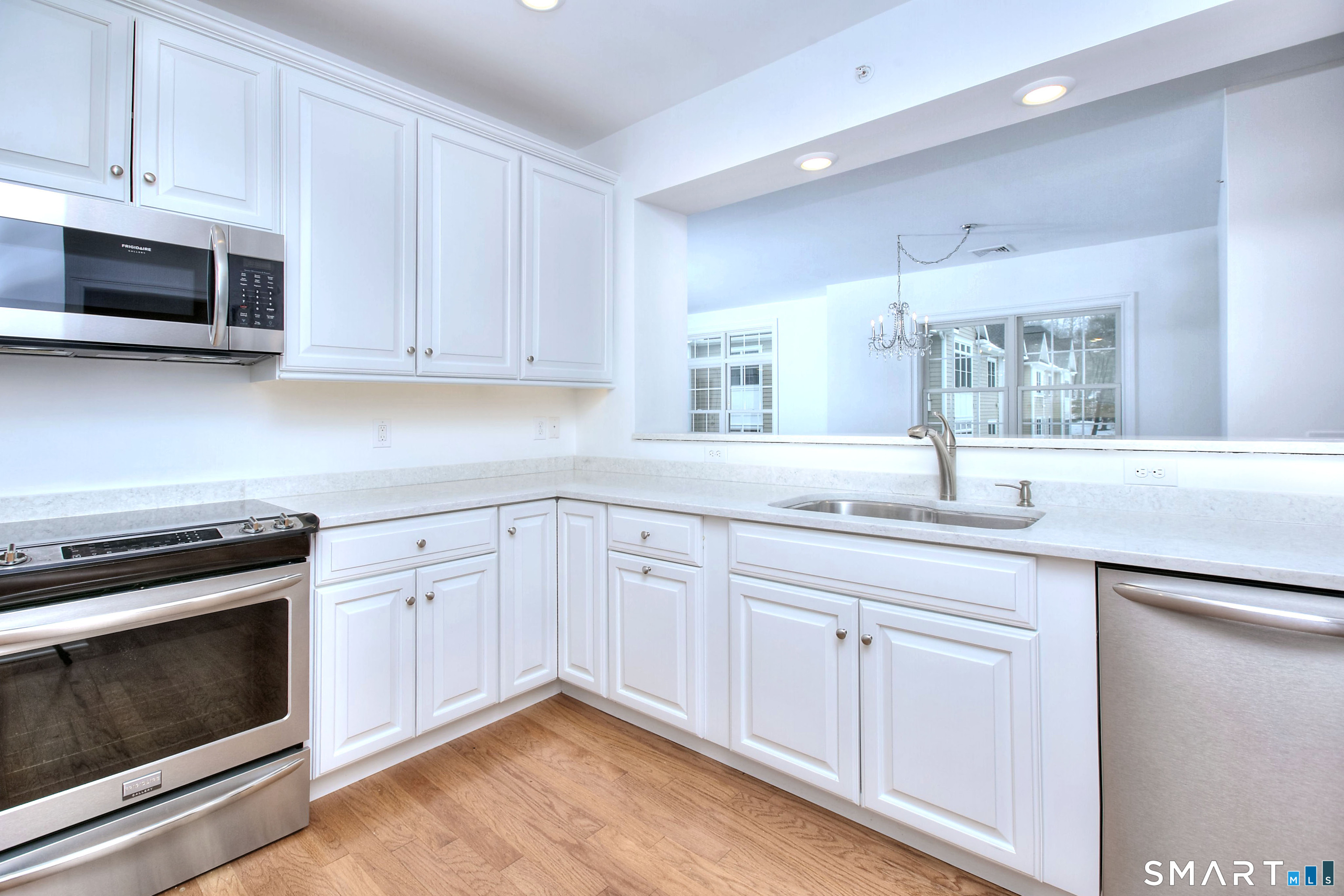 77 Sunset Lane, Unit 335 Ridgefield, CT 06877 - Photo 4 of 25 a kitchen with white cabinets appliances and sink