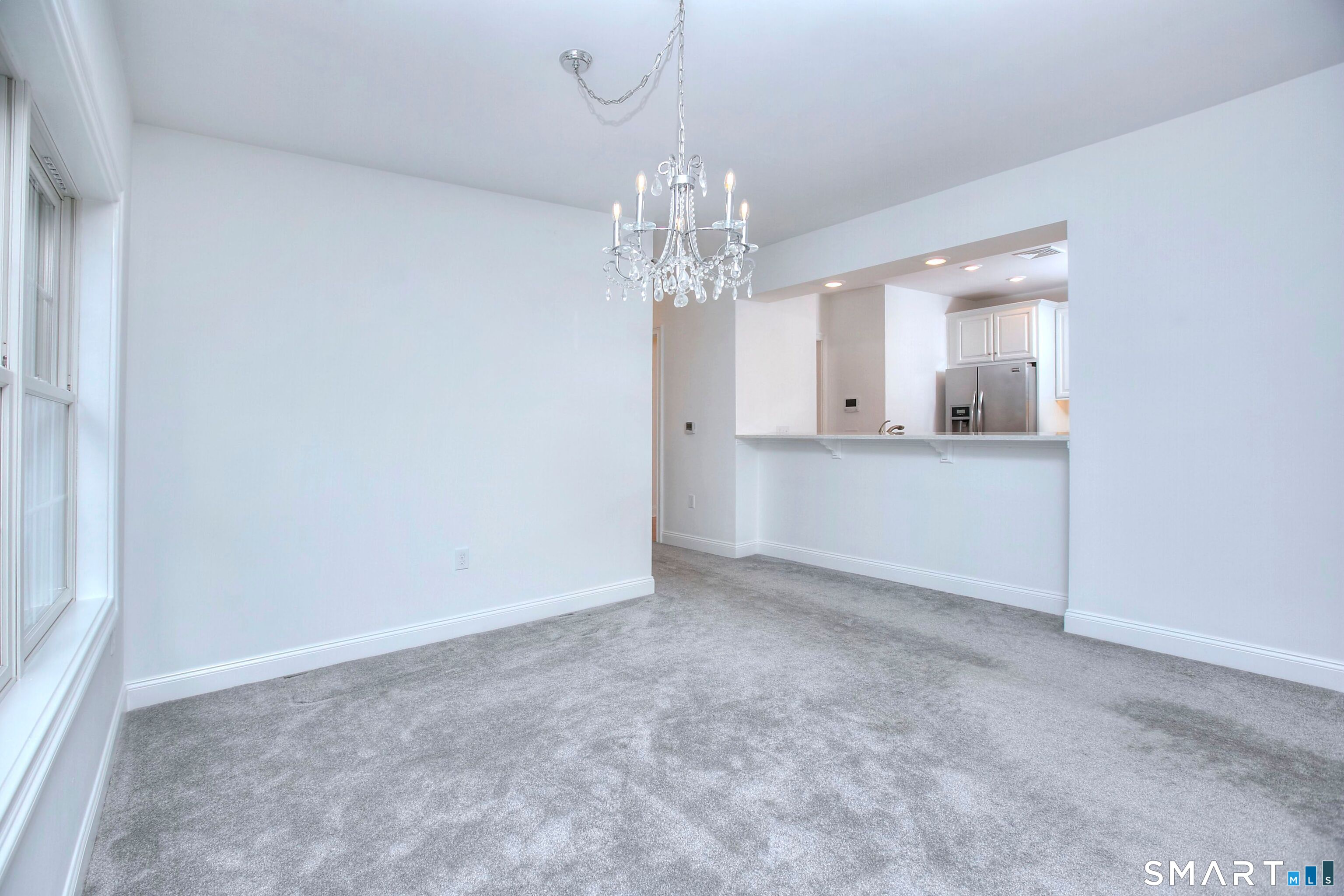 77 Sunset Lane, Unit 335 Ridgefield, CT 06877 - Photo 5 of 25 a view of a chandelier in a room and a kitchen