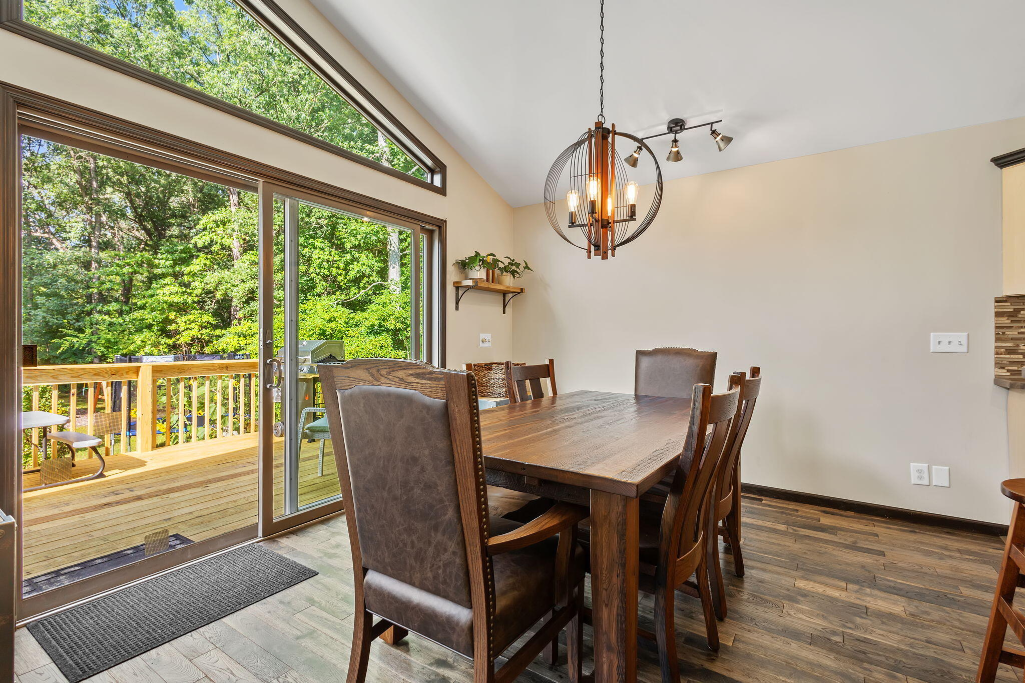5592 East 1100th Street North Demotte, IN 46310 - Photo 17 of 77 a dining room with wooden floor a chandelier a wooden table and chairs