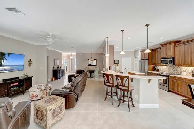 a large kitchen with kitchen island a stove a table a sink and a refrigerator