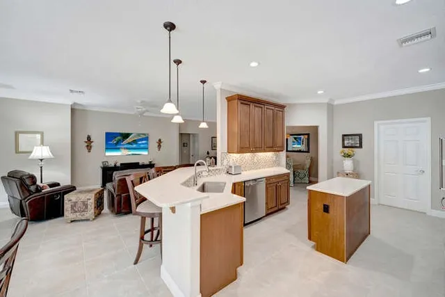 a kitchen with stainless steel appliances kitchen island granite countertop a sink a stove and a refrigerator