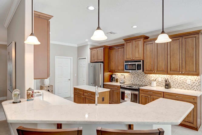 636 Gossamer Wing Way Sebastian, FL 32958 - Photo 8 of 34 a kitchen with stainless steel appliances kitchen island granite countertop a sink a stove and a refrigerator