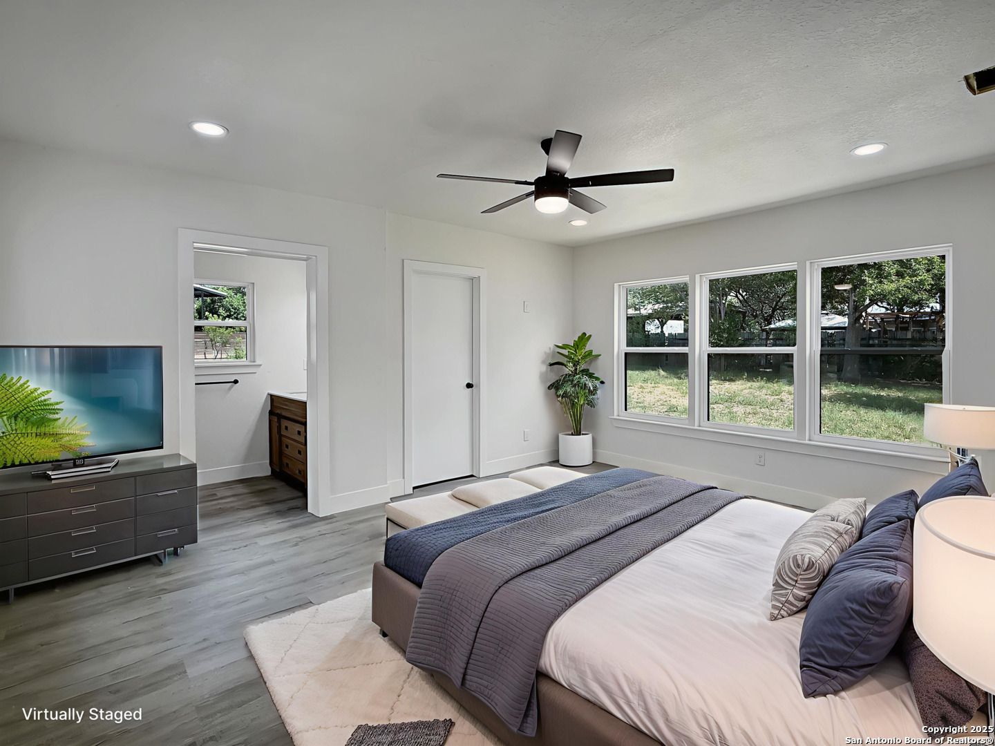 519 Jackson Keller Road San Antonio, TX 78216 - Photo 24 of 40 a spacious bedroom with a large bed and a flat screen tv