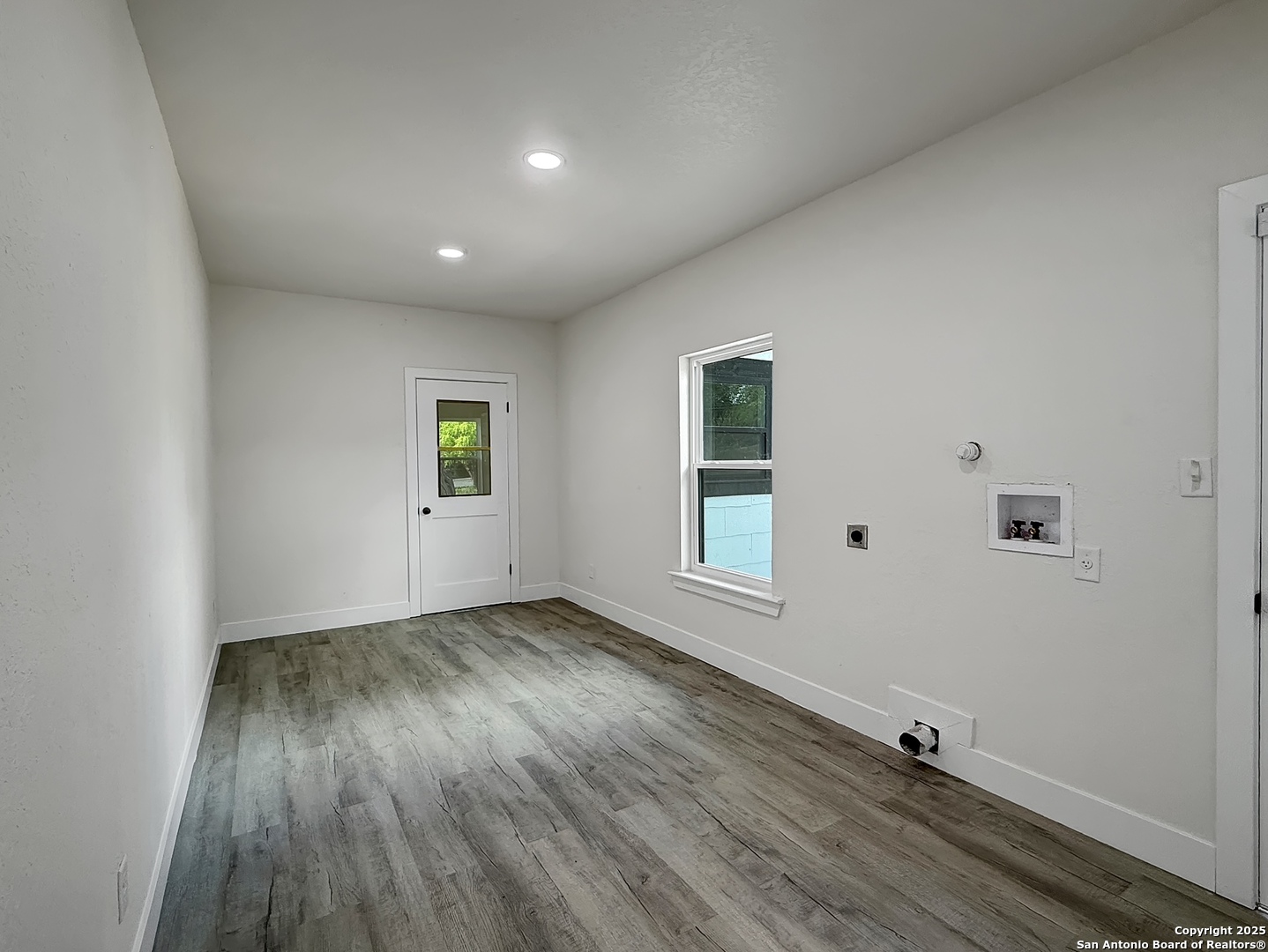 519 Jackson Keller Road San Antonio, TX 78216 - Photo 32 of 40 an empty room with wooden floor and windows
