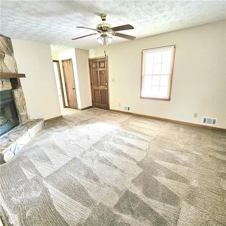 an empty room with windows and fireplace