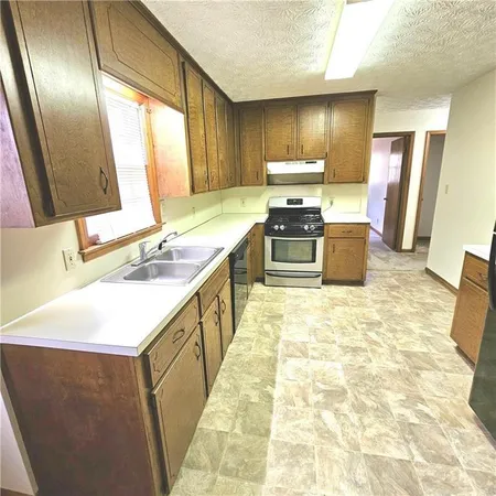 a kitchen with stainless steel appliances a stove sink and a refrigerator