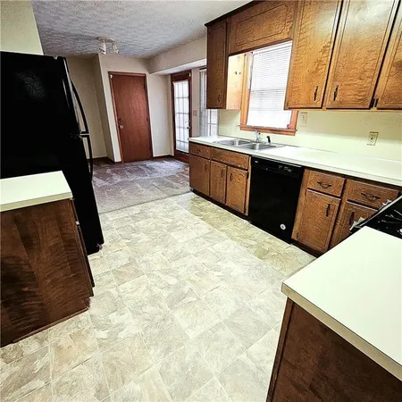 a kitchen with stainless steel appliances a sink stove and cabinets