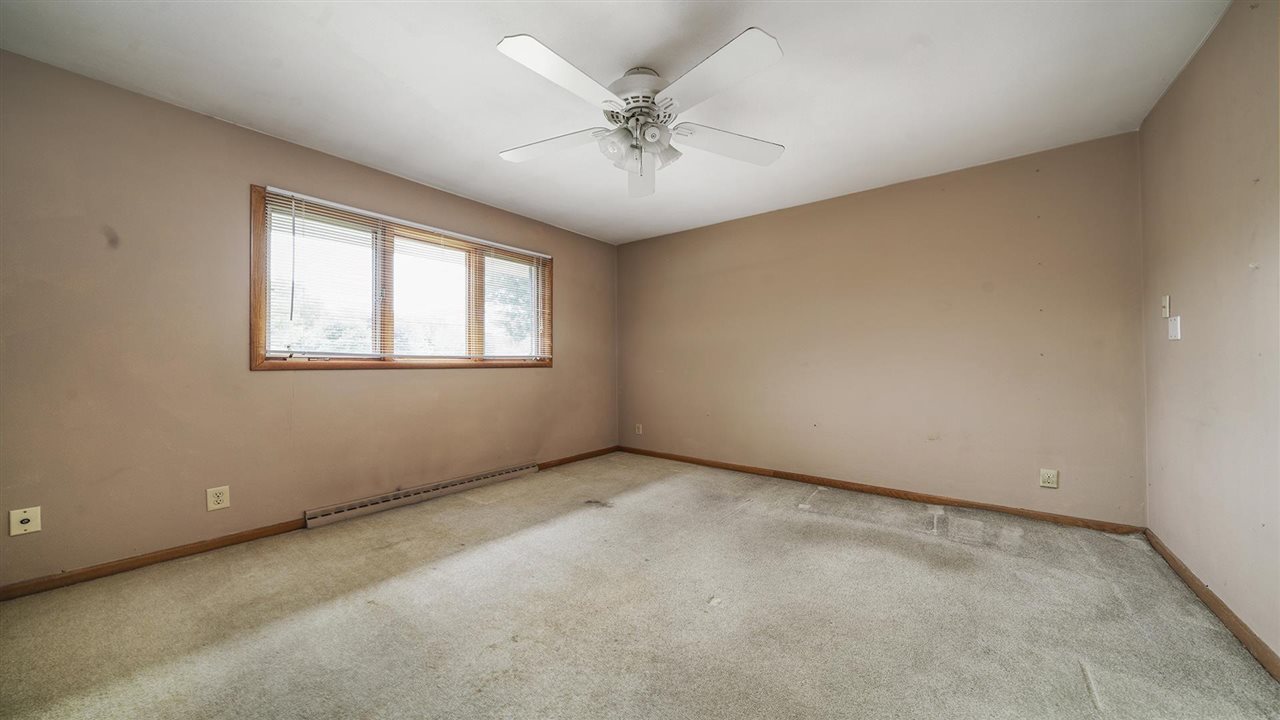 4114 Landstrom Road Rockford, IL 61114 - Photo 20 of 38 an empty room with a chandelier fan and windows