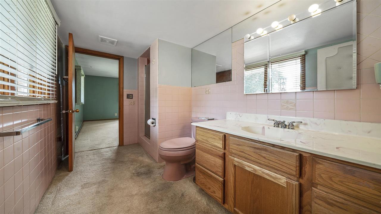 4114 Landstrom Road Rockford, IL 61114 - Photo 24 of 38 a bathroom with a granite countertop sink a toilet and mirror
