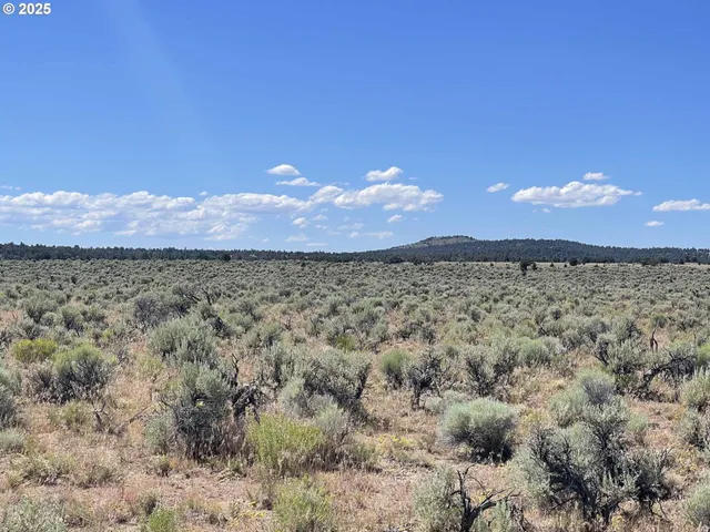a view of mountain with sunset in background