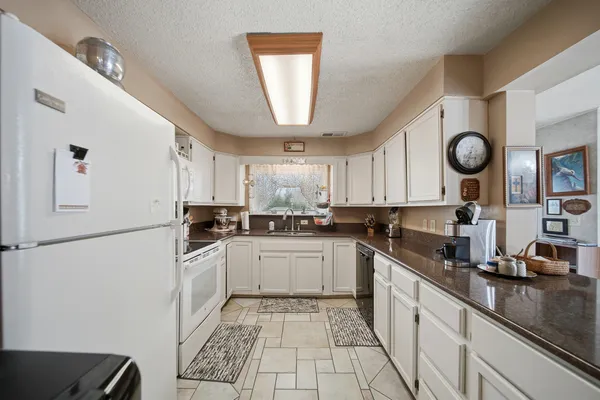 a view of a refrigerator in kitchen and a window