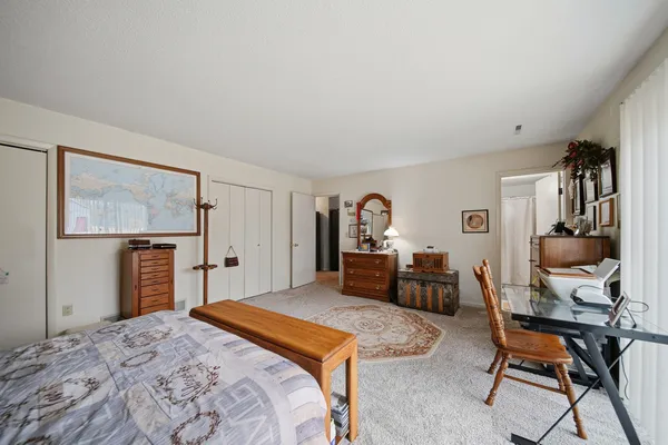 a bedroom with a large bed and a chandelier