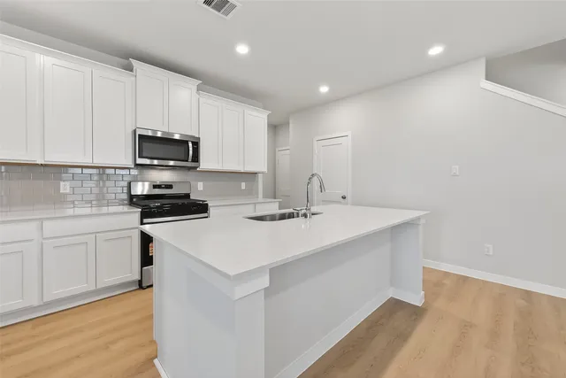 a kitchen with appliances a sink and cabinets