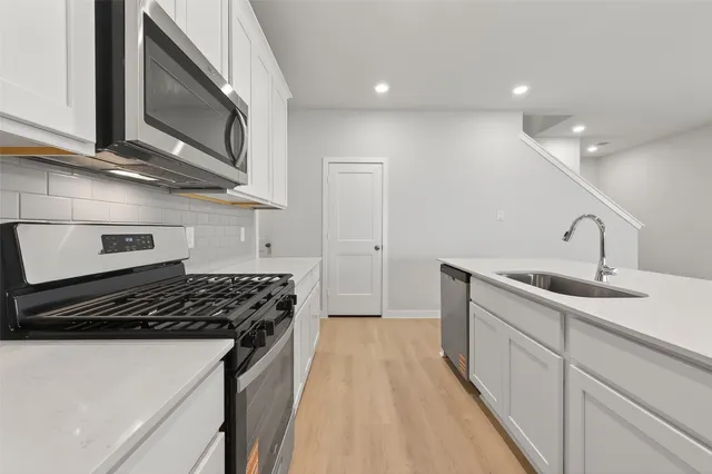 a kitchen with sink a stove and cabinets