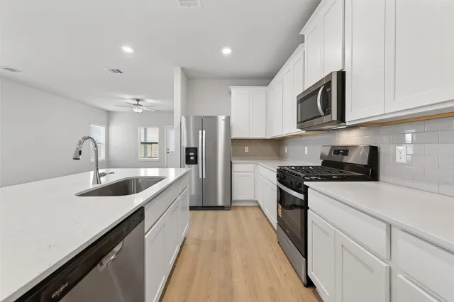a kitchen with stainless steel appliances granite countertop a sink stove and refrigerator