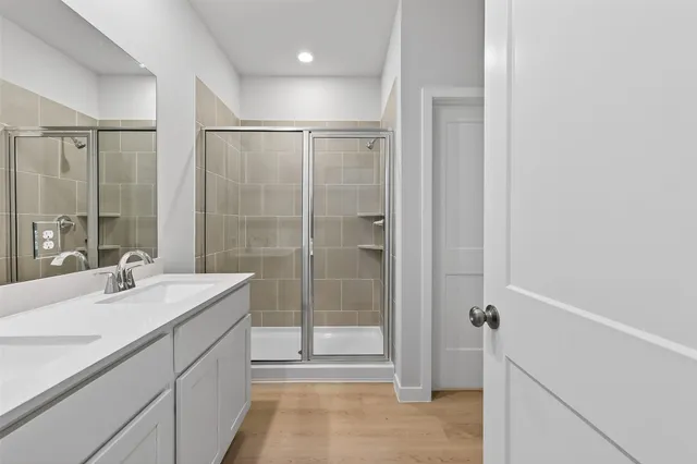 a bathroom with a shower sink and mirror