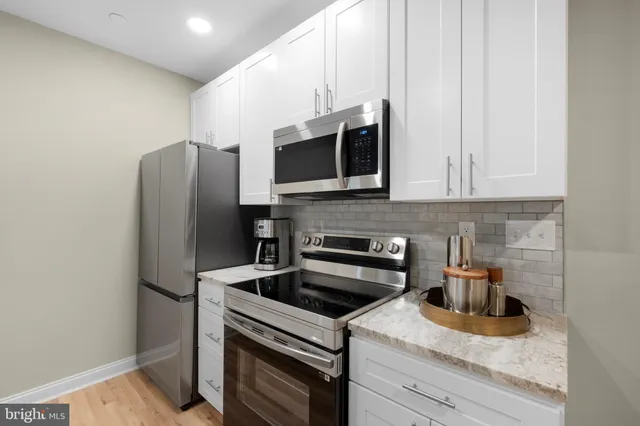a kitchen with stainless steel appliances granite countertop a refrigerator stove and sink