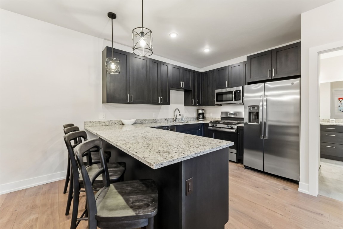 235 La Bonte Street, Unit 106 Dillon, CO 80435 - Photo 34 of 37 a kitchen with kitchen island a refrigerator stove a sink and chairs