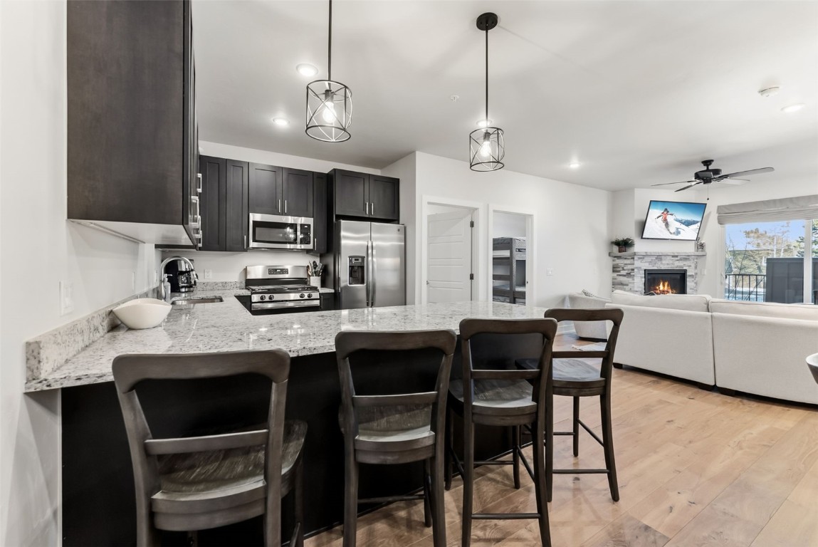 235 La Bonte Street, Unit 106 Dillon, CO 80435 - Photo 4 of 37 a kitchen with stainless steel appliances a dining table chairs and white cabinets