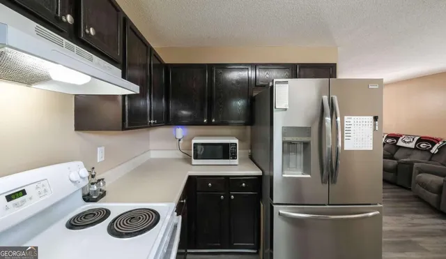 a kitchen with a refrigerator and a stove top oven