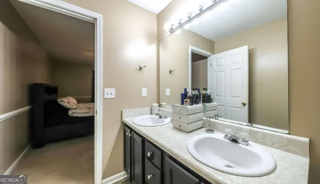 a en suite bathroom with a double vanity sink and a mirror
