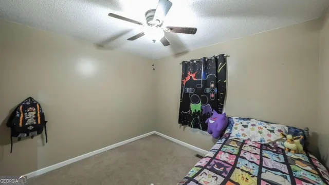 a bedroom with a bed and a chandelier fan