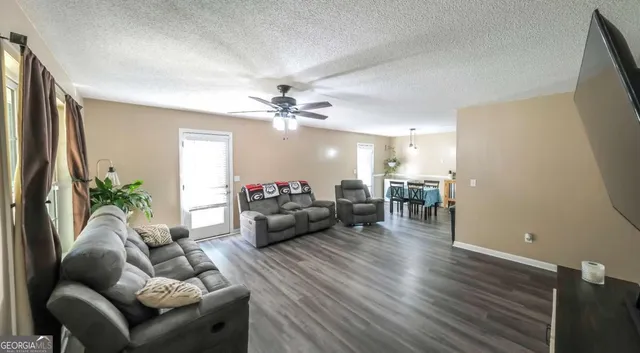 a living room with furniture and a wooden floor