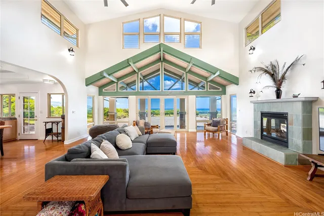 a living room with furniture a fireplace and a floor to ceiling window