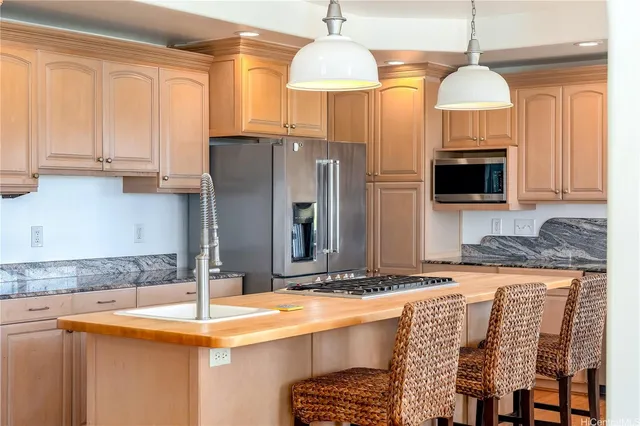 a kitchen with stainless steel appliances granite countertop a sink refrigerator and microwave