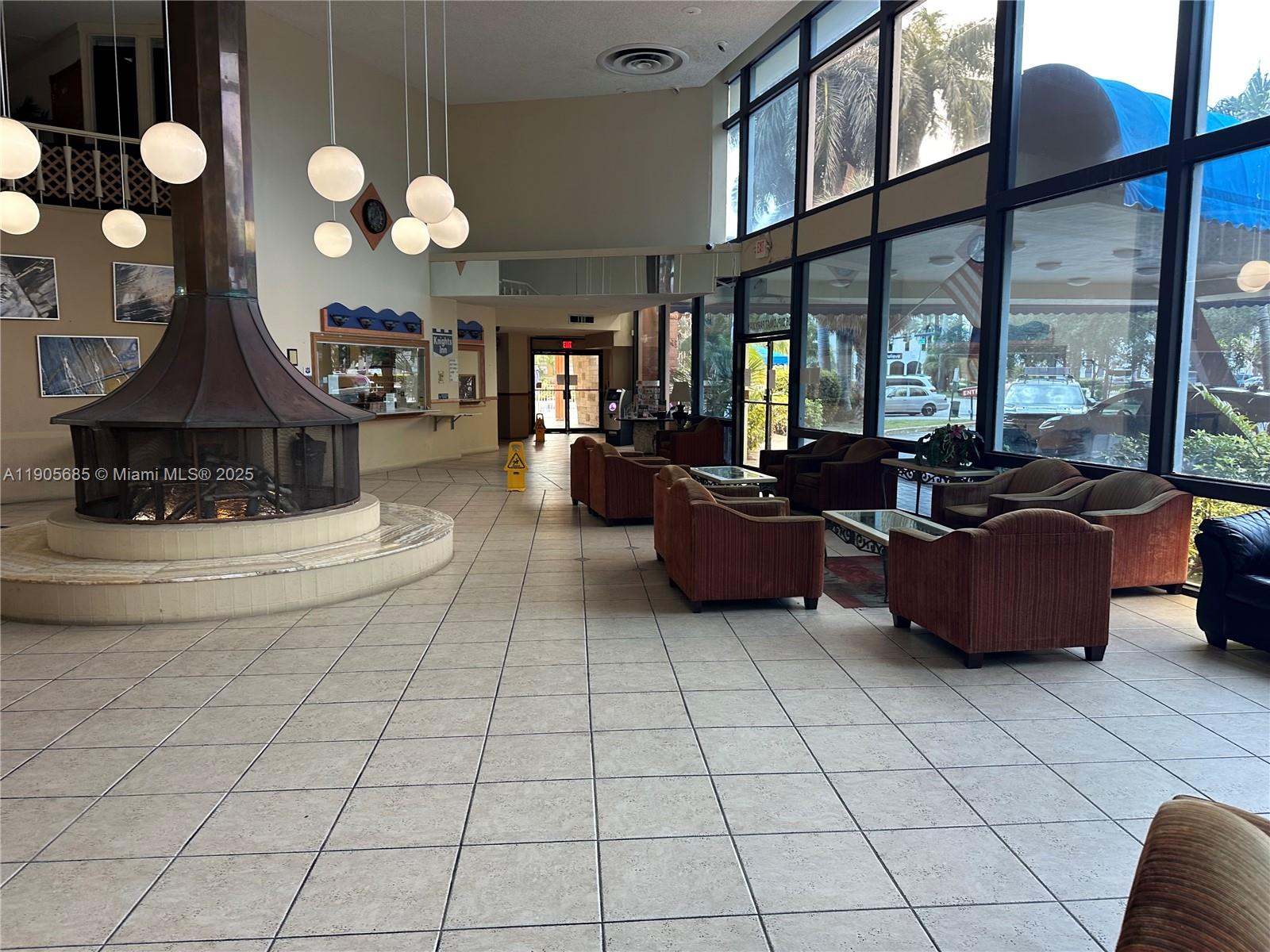 26 Diplomat Parkway, Unit 2314 Hallandale Beach, FL 33009 - Photo 13 of 15 a living room with furniture a chandelier and a large window