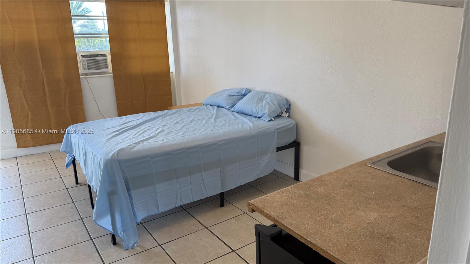 26 Diplomat Parkway, Unit 2314 Hallandale Beach, FL 33009 - Photo 9 of 15 a bed sitting in a bedroom next to a window