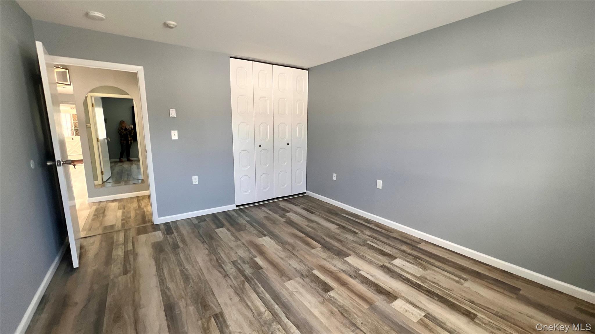 421 Weymouth Court, Unit D Ridge, NY 11961 - Photo 12 of 21 an empty room with wooden floor and entrance