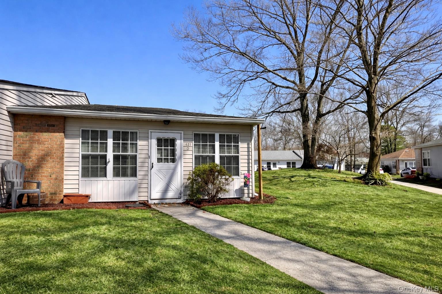 421 Weymouth Court, Unit D Ridge, NY 11961 - Photo 2 of 21 a front view of a house with a yard and outdoor seating