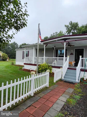 a view of a house with wooden deck and a yard