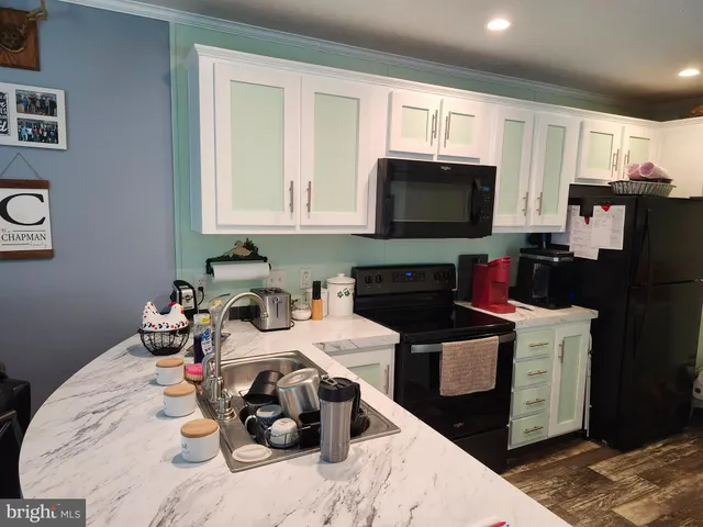 a kitchen with a sink dishwasher and a stove top oven with wooden floor