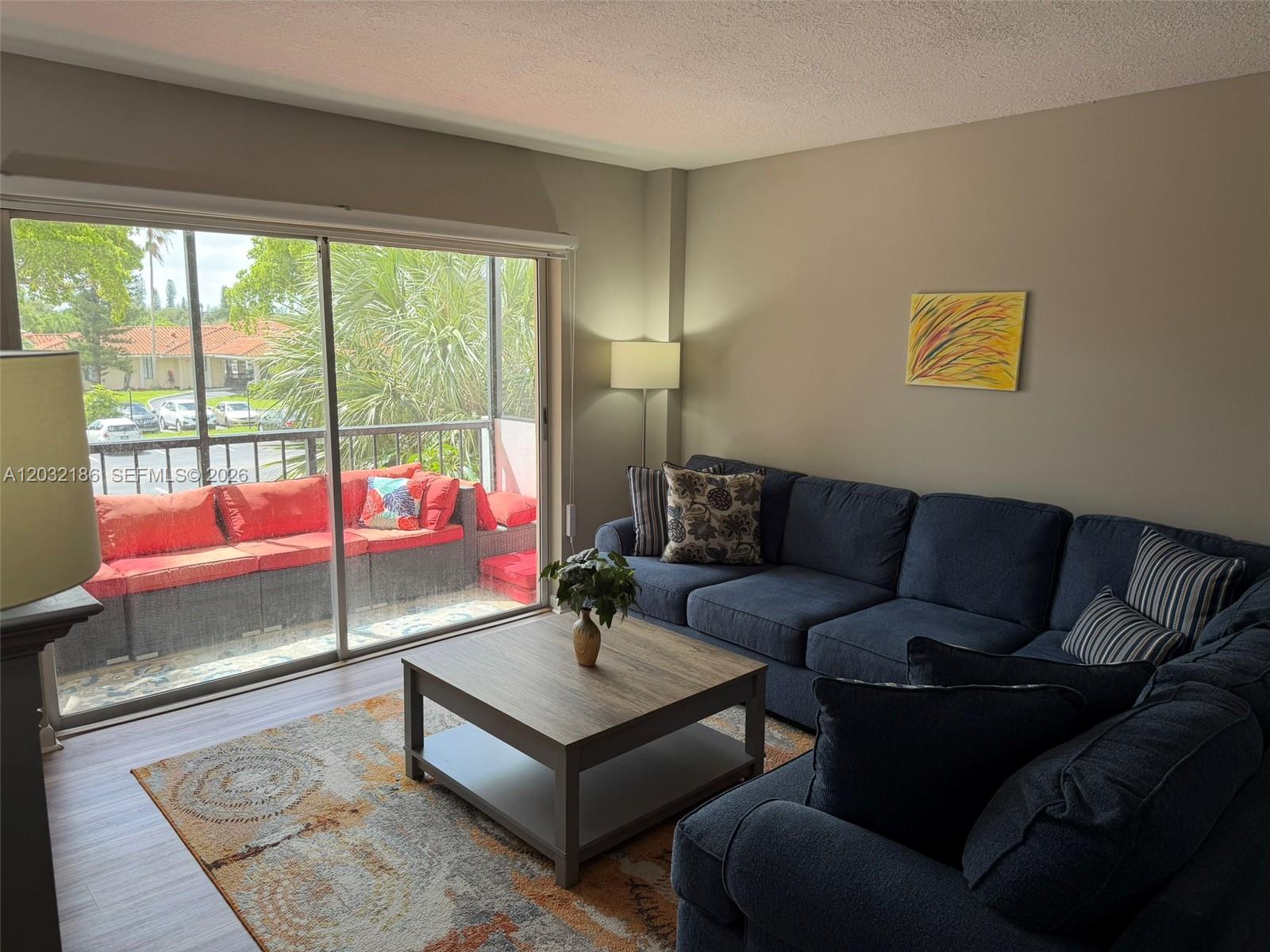 4164 Inverrary Drive, Unit 204 Lauderhill, FL 33319 - Photo 10 of 28 a living room with furniture and a floor to ceiling window